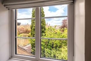 A window with a view of a garden and houses. - Old Bank Flat Beautiful Cotswold Apt (Bourton on the water)