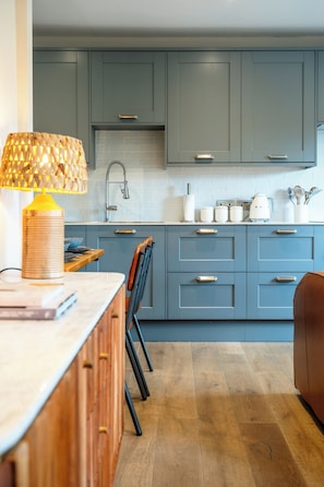 A modern kitchen with grey cabinets, a wooden countertop, and a lamp. - Old Bank Flat Beautiful Cotswold Apt (Bourton on the water)