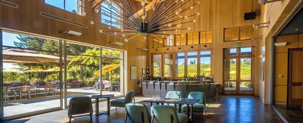 An indoor dining area with tables and chairs, large windows, and a view of the outdoors. - Luxury Forestville Ranch: Pool+Hot Tub+Fire Pit (Forestville)