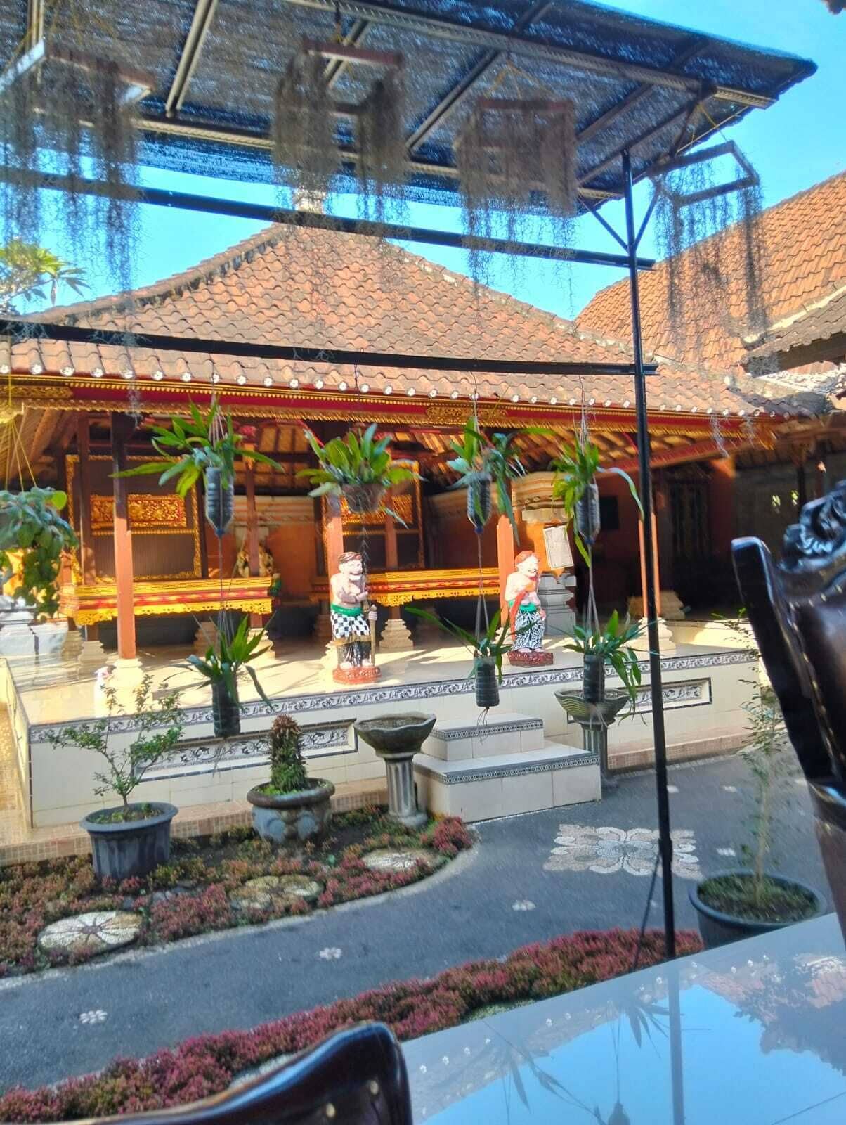 A traditional building with a tiled roof, a covered seating area, and potted plants.