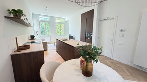 Una cocina moderna con una isla central, armarios de madera y un comedor con una mesa redonda.