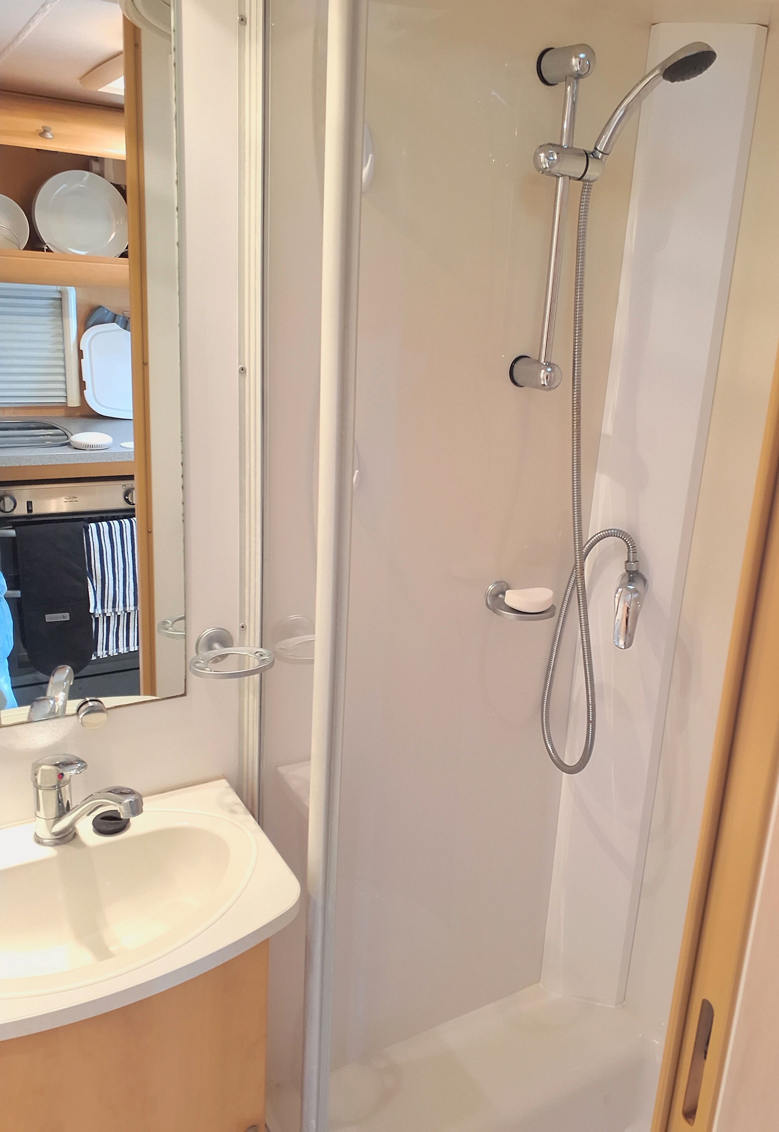Ein Badezimmer mit Dusche, Waschbecken und Spiegel.