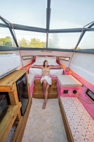 Un ambiente acogedor con una cama, una mesa de madera y una pequeña cocina.