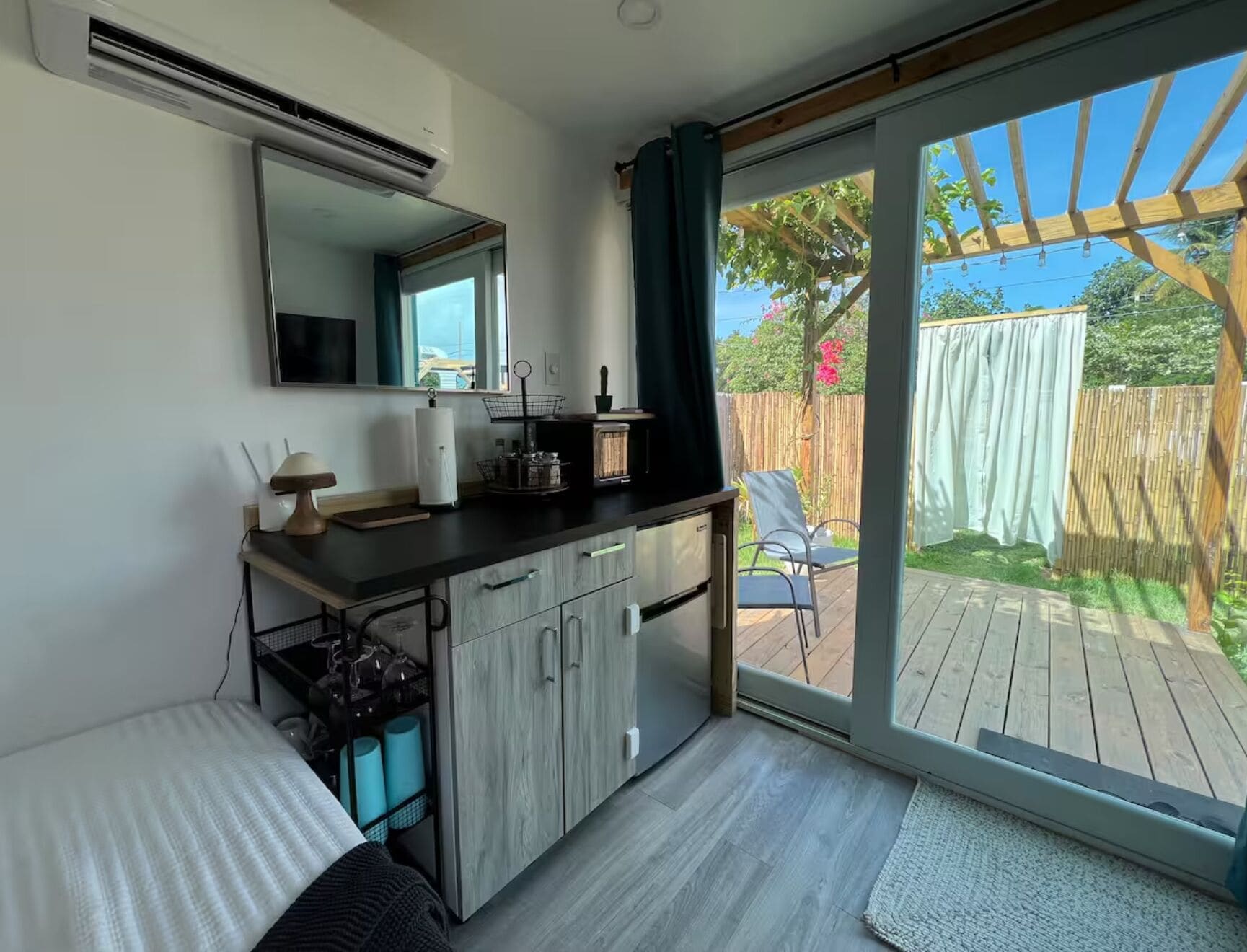 Una cocina moderna con un amplio ventanal, puerta corrediza a una terraza y un pequeño comedor.