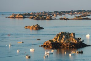 A coastal scene with rocky outcrops and boats anchored in calm waters. - Ker Koad - PLOURIVO - Gîte (PLOURIVO)