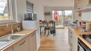 Eine moderne Küche mit Holzarbeitsplatte, Spüle aus Edelstahl und einem Essbereich mit Tisch und Stühlen.