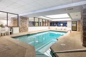 Ein Innenpool mit Steinwänden und freiem Blick in den angrenzenden Raum.