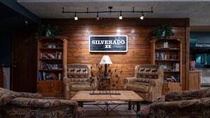 A cozy room with a wooden wall, a sign reading 'SILVERADO II,' leather armchairs, a coffee table, and bookshelves. - Ski Retreat Condo w/ Pool, Hot Tub & Balconies (Winter Park)