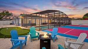 Un espace piscine doté d’un coin salon abrité, d’un foyer et d’un green d’entraînement au putting.