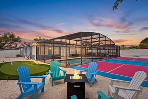 Ein Poolbereich mit überdachter Lounge, Feuerstelle und Putting-Green.