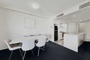 Una cocina moderna con armarios blancos, un refrigerador negro y un lavamanos.