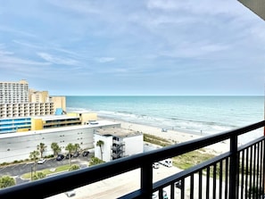Ein Strandhotel mit Blick auf den Ozean, einem Parkplatz und einer Straße.