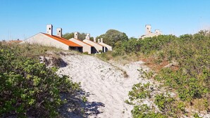 A series of buildings with a sloped roof, situated on a sandy terrain with sparse vegetation. - 6 Person Holiday Park Home in Saeby (Sæby)