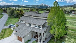 Une maison à deux étages avec un porche couvert, un garage et une allée.