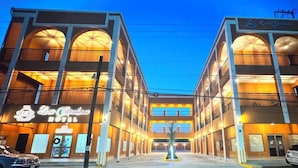 Um hotel com um pátio central, várias varandas e uma área de recepção.