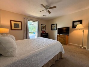 A bedroom with a bed, a ceiling fan, a TV, a dresser, and a window with curtains. - 2BR Condo in Pointe Royale with View ~ 2 Pools ~ FREE TICKETS INCLUDED! (PR2-6) (Branson)