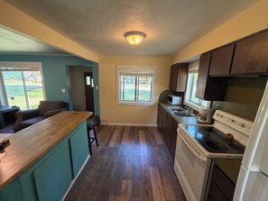 Una cocina con armarios de madera, estufa y lavabo.