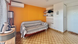 A bedroom with a bed, a desk with a lamp, an air conditioner, and a wardrobe. - CAP D'AGDE - Plage du Môle / Réf 0101 (CAP D'AGDE)