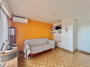 A bedroom with a bed, a desk with a lamp, an air conditioner, and a wardrobe. - CAP D'AGDE - Plage du Môle / Réf 0101 (CAP D'AGDE)