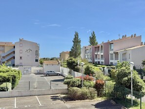 Ein Wohngebiet mit Mehrfamilienhäusern, einem Parkplatz und Grünflächen.
