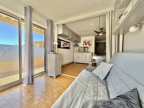 Ein modernes Wohnzimmer mit Sofa, Essbereich und Küche.
