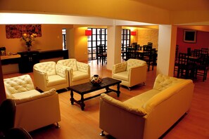 Un amplio salón con un conjunto de sofás, una mesa de centro y una zona de comedor con sillas y una mesa.