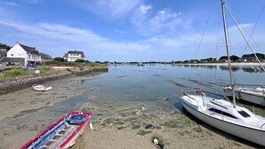 A coastal scene with a marina, boats, and houses along the shore. - Maguyann - PLOUHARNEL (PLOUHARNEL)