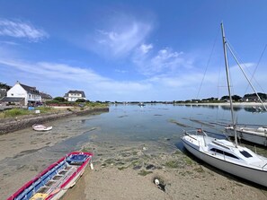 A coastal scene with a marina, boats, and houses along the shore. - Maguyann - PLOUHARNEL (PLOUHARNEL)