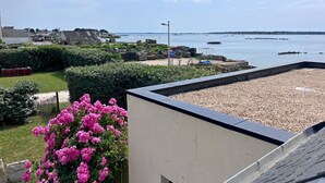 A coastal view with a pebbled beach, a garden with pink flowers, and a clear sky. - Maguyann - PLOUHARNEL (PLOUHARNEL)