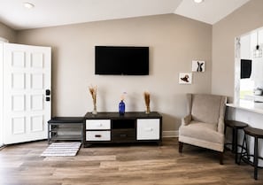 Ein Wohnzimmer mit Fernseher, einer Couch, einem Couchtisch und einem Schrank.