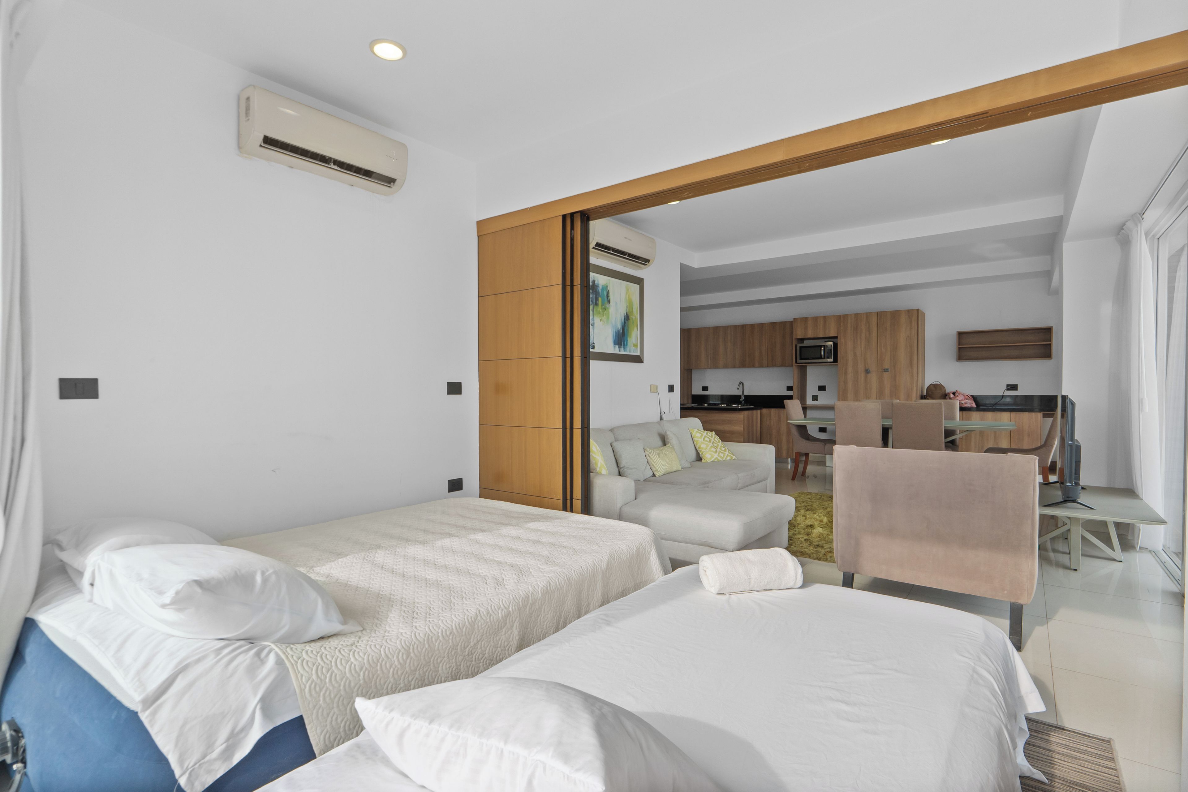 Ein Hotelzimmer mit zwei Betten, einer Küchenzeile und einem Essbereich.