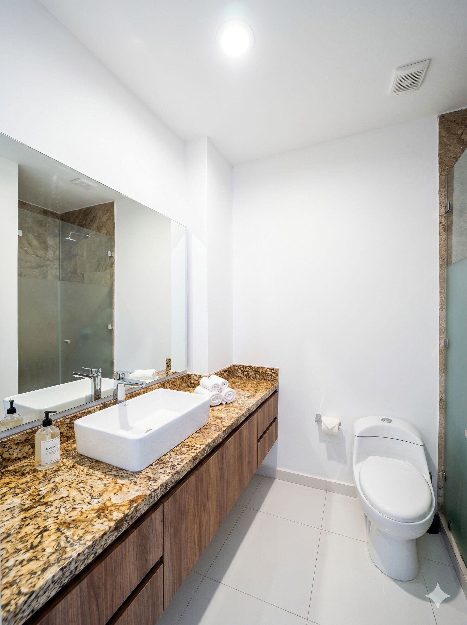 Een moderne badkamer met een grote spiegel, twee wasbakken, een toilet en een douchehoek.