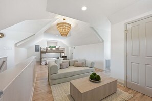 Ein modernes Schlafzimmer im Loft-Stil mit schrägem Dach, integriertem Bett, einer Couch und einem Couchtisch.