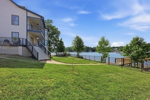 Ein zweistöckiges Gebäude mit Balkon, Rasengrundstück und Seeblick.