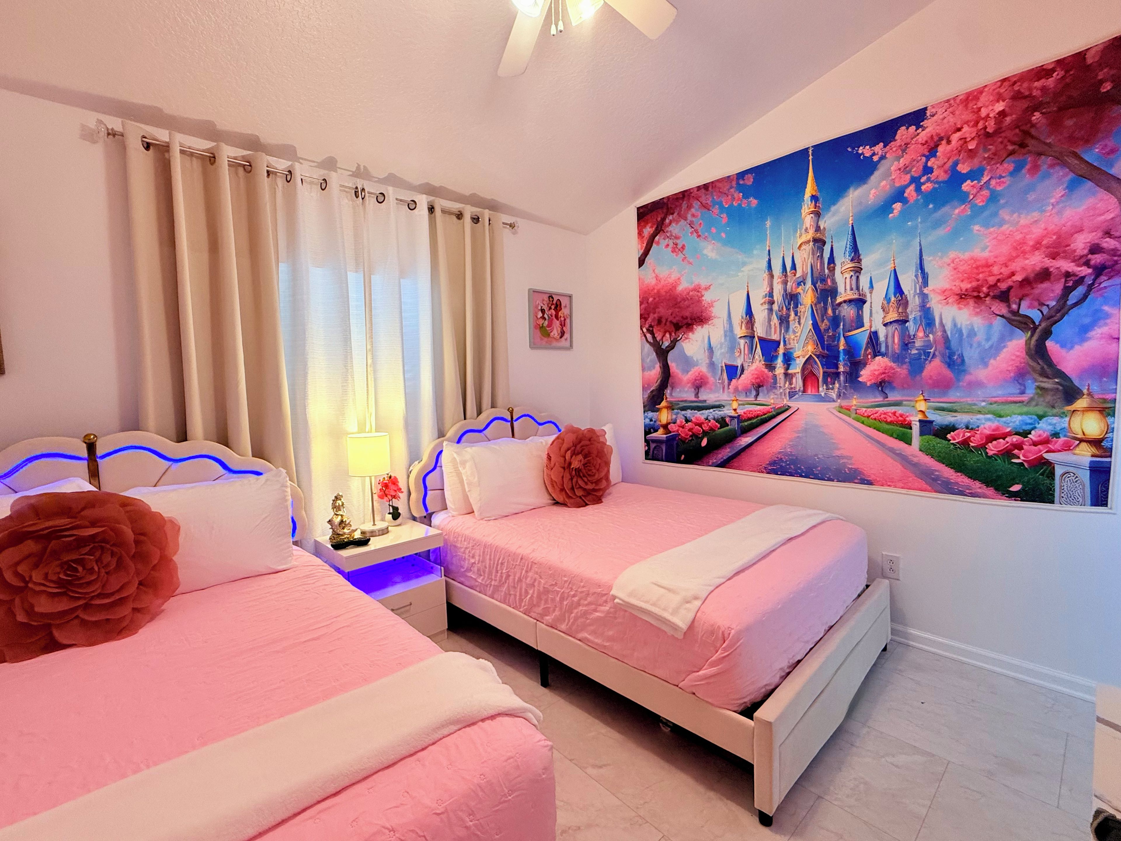 A bedroom with two beds, a nightstand with a lamp, and a large wall mural of a castle.