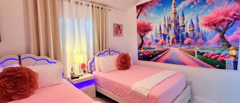 A bedroom with two beds, a nightstand with a lamp, and a large wall mural of a castle.