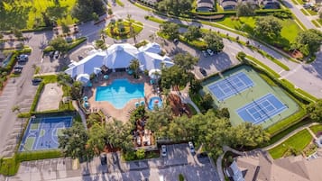 Luchtbeeld van een woongebied met een zwembad, tennisbanen en een aangelegde park.