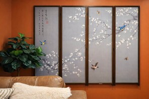 A room with a traditional sliding door, a potted plant, and a brown leather sofa. - 4 Beds | Parking | Chinatown | 20' Ceilings (Philadelphia)