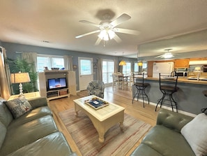 Ein Wohnzimmer mit Sofa, Couchtisch, Fernseher und Deckenventilator.