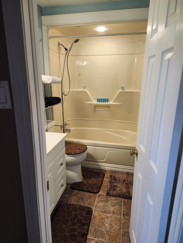 Une salle de bain comprenant des toilettes, un lavabo, une baignoire et une douche.
