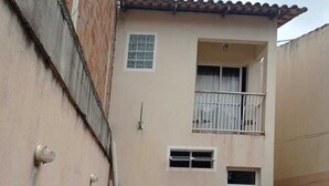 A two-story building with a balcony, a small window, and a door. - Quiet corner (Igarapé)