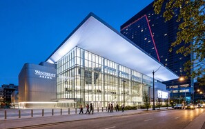 A modern building with a glass facade and a prominent 'Wintrust Arena' sign. - McCormick Place Modern Suite for 4, with Optional Parking (Chicago)