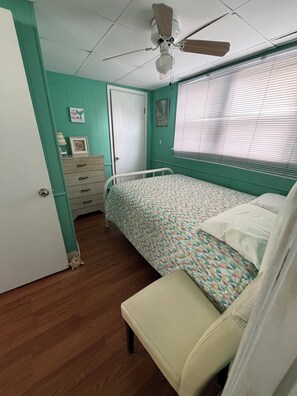 A bedroom with a bed, a dresser, a ceiling fan, and a window with blinds. - 3-bedroom 1st Floor cottage unit 100 yards from beach (Old Lyme)