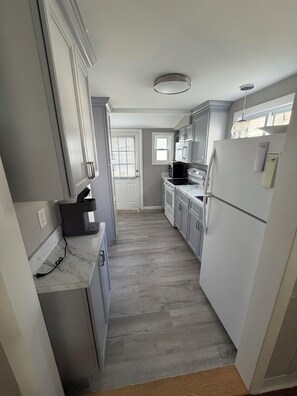 Eine Küche mit Mikrowelle, Backofen und Kühlschrank.
