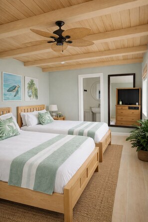 A bedroom with two wooden beds, a ceiling fan, a bathroom visible through an open door, a TV stand, and a potted plant. - Xanadu Resort Roatan (Sandy Bay)