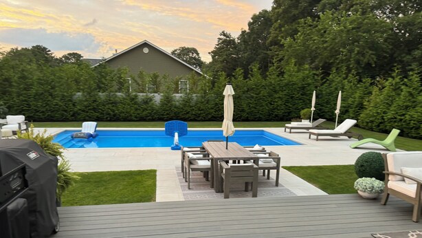 A backyard with a swimming pool, patio furniture, and a grill. - Hamptons Retreat Pool Oasis Modern House (Hampton Bays)