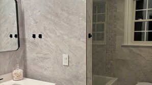 A modern bathroom with a marble floor, a glass shower enclosure, a white sink, and a toilet. - Hamptons Retreat Pool Oasis Modern House (Hampton Bays)