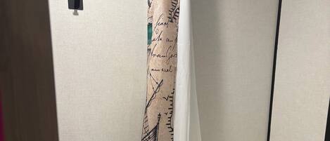 Ein Badezimmer mit Toilette, einer Duschkabine mit Meeresmotiv und Pflegeprodukten am Waschbecken.