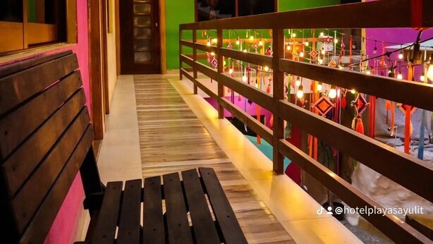 A brightly lit corridor with a wooden bench, a railing with hanging lights, and a door marked with the number 17. - Amaizing Place in Sayulita (Sayulita)