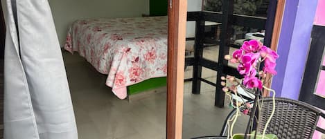 Een kamer met een bed, een stoel, een tafel en een raam.